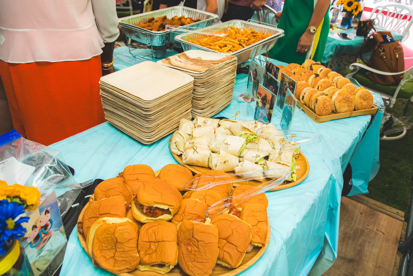Catering trays of sliders, wraps and sandwiches laid out on a party table at Uncle Rocco